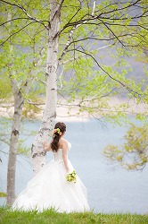 結婚式の前撮りで、ウェディングドレスの花嫁の、かわいいダウンスタイルのヘアメイクの写真 width=